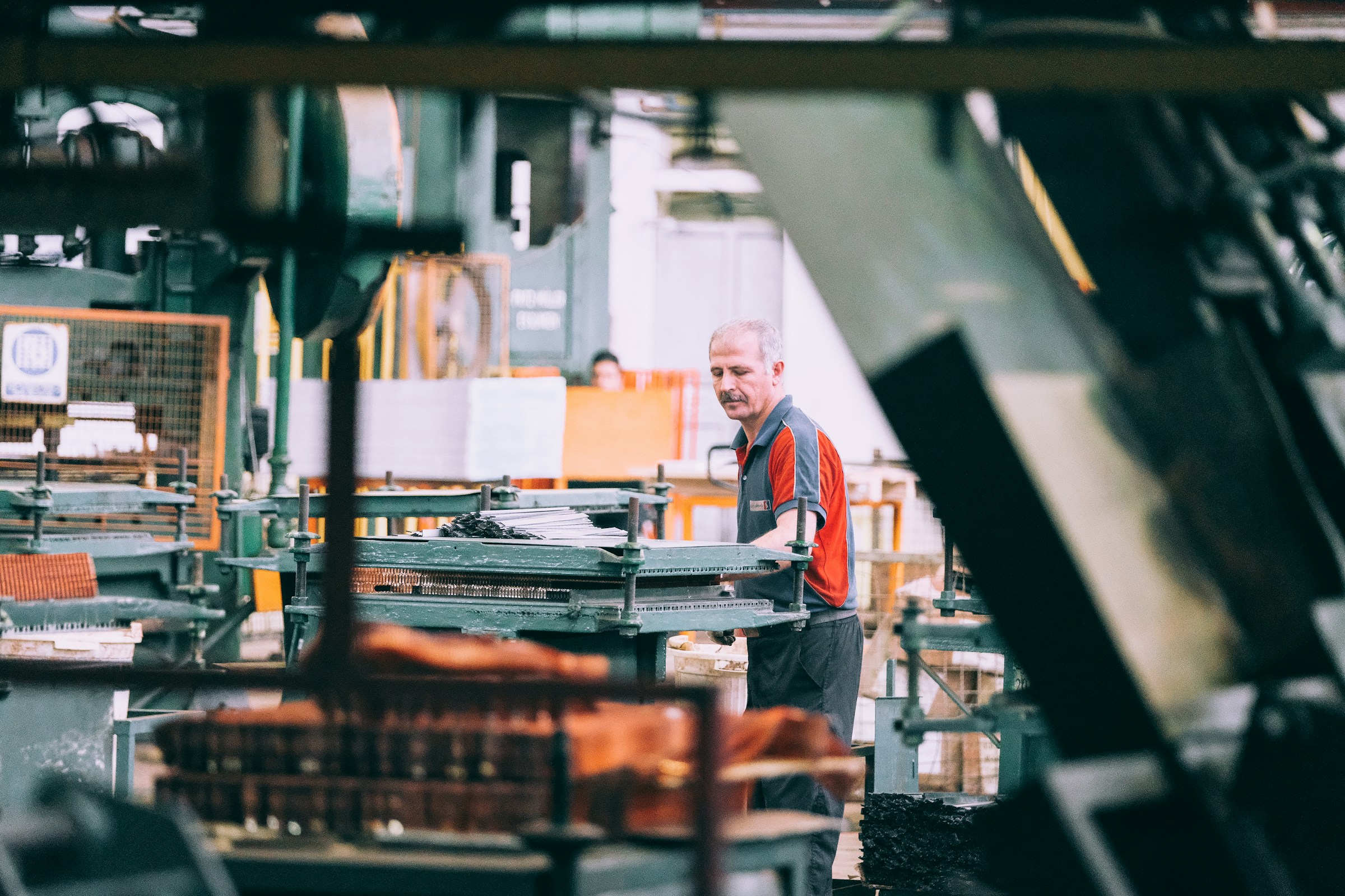A worker at a press in a metal workshop